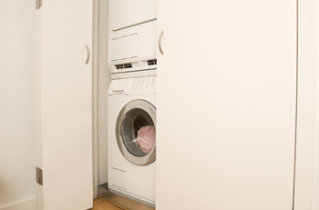 a white washer and dryer in a white closet